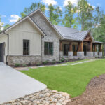 Front view of a custom home in Travelers Rest with cedar beams, brickwork, and 3-car garage.