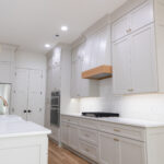 Custom kitchen with quartz countertops, bronze fixtures, and high ceilings